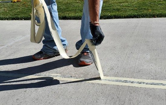 Man Lifting Tape From Grout Seam